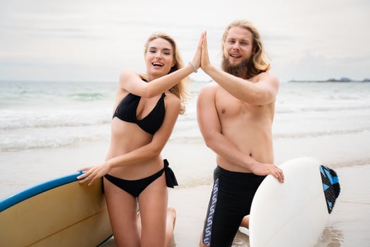 Two surfers giving high five on the beach. Two surfers having fun on the beach. photo