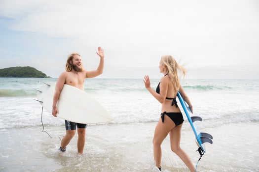 Two surfers giving high five on the beach. Two surfers having fun on the beach. photo