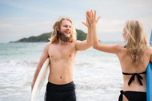 Two surfers giving high five on the beach. Two surfers having fun on the beach. photo