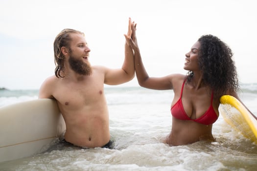 Two surfers giving high five on the beach. Two surfers having fun on the beach. photo