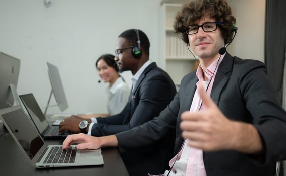 Group of business people wearing headset working actively in office. Call center, telemarketing, customer support agent provide service on telephone video conference call. photo