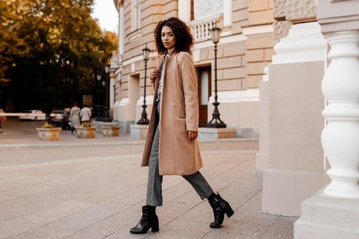 Fashion  full length  image of elegant  black woman in stylish luxury beige coat and velvet sweater, hight heels, walking outdoor. photo