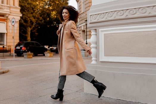 Fashion  full length  image of elegant  black woman in stylish luxury beige coat and velvet sweater, hight heels, walking outdoor. photo