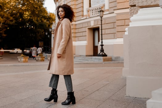 Fashion  full length  image of elegant  black woman in stylish luxury beige coat and velvet sweater, hight heels, walking outdoor. photo