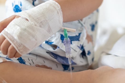 Close up child hand with saline IV solution in hospital photo
