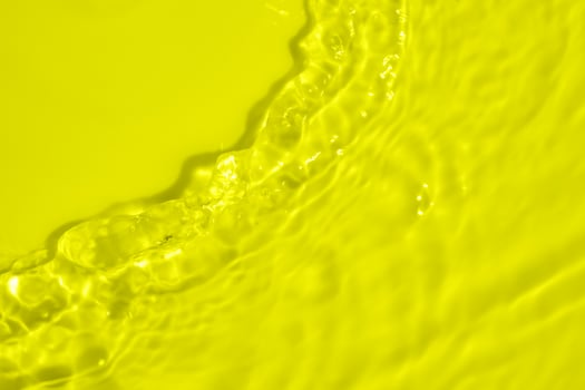 Abstract transparent water shadow surface texture natural ripple on yellow background photo