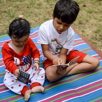 Two happy boys in society park, happy Asian brothers who are smiling happily together. Brothers play outdoors in summer, best friends. Toddler baby boy playing with his happy brother in the garden photo