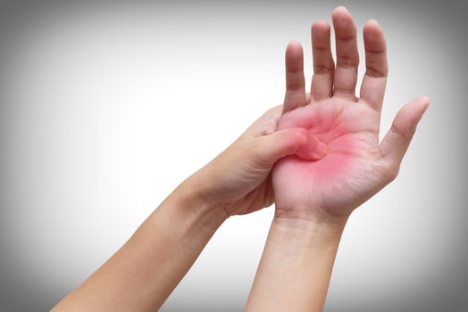 Woman holding her hand with acute pain in palm isolated on white background. Medical treatment and pain concept. Color Manipulation image to emphasize the pain photo