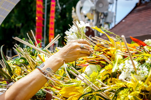 Closeup hand of people put a fragrant flowers with incense on heap of flowers in the Thai Lanna dedicate a bouquet of flowers to worship the Buddha tradition. photo
