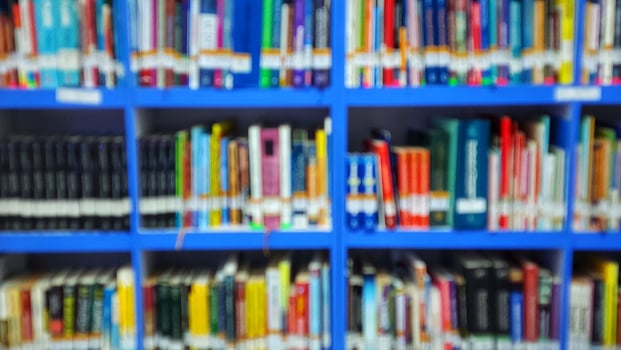 a blurry image of books on a shelf in a library photo