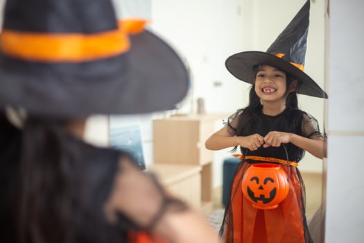 Happy Asian child girl in a witch costume to Halloween. trick or treat. Kids trick or treating. photo