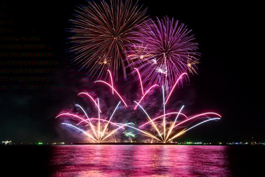 Amazing beautiful colorful fireworks display on celebration night, showing on the sea beach with multi color of reflection on water photo