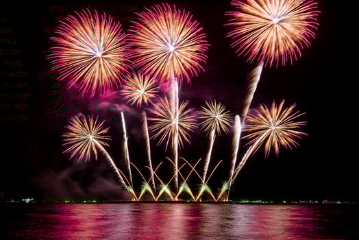 Amazing beautiful colorful fireworks display on celebration night, showing on the sea beach with multi color of reflection on water photo