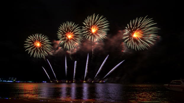 Amazing beautiful colorful fireworks display on celebration night, showing on the sea beach with multi color of reflection on water photo