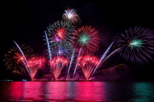 Amazing beautiful colorful fireworks display on celebration night, showing on the sea beach with multi color of reflection on water photo