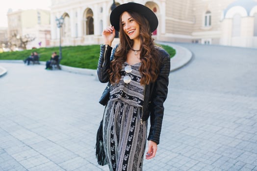 Lifestyle portrait of pretty cheerful woman  enjoying  holidays in old European city.  Street fashion  look.   Stylish spring outfit. photo