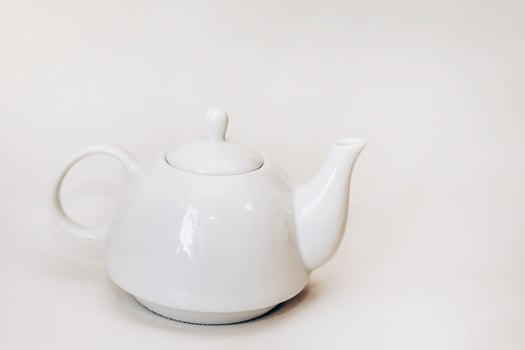 White ceramic teapot infuser on white background photo