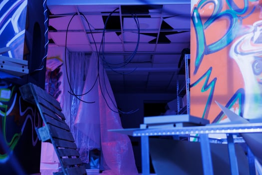 Demolished structure with neon lights turned into chaos, abandoned urban building glowing in the darkness of deserted warehouse. Neglected space with fluorescent purple glowy light. photo