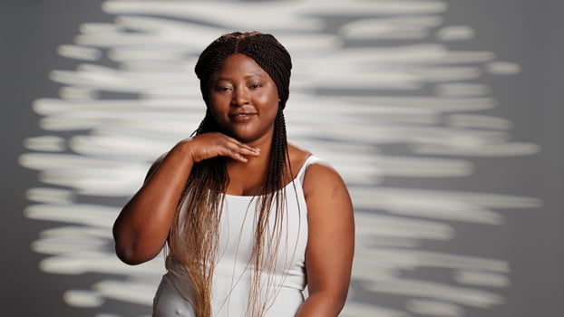 Young person embracing imperfections on camera, posing for empowering skincare ad campaign. Positive gentle woman with natural radiant skin feeling confident with body and skintone. photo