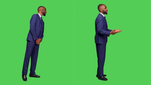 Male office worker in formal suit waiting in studio, looking around over full body green screen. Startup employee feeling confident and stylish on camera, greenscreen background. photo