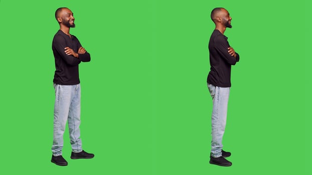 African american person smiling in studio and posing, wearing shirt and jeans over full body green screen background. Young adult feeling confident and positive, casual male model. photo