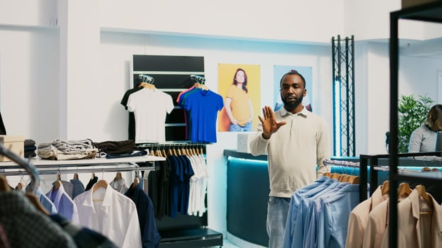 African american shopper using hologram in boutique to check new clothing store merchandise with augmented reality. Male customer looking at holographic footage, artificial intelligence. photo