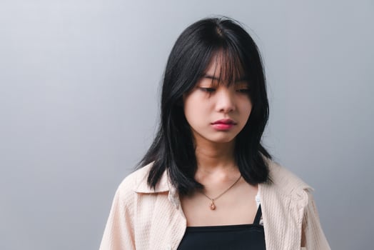 Young beautiful Asian teenage girl showing a sad, disappointed expression on background. photo