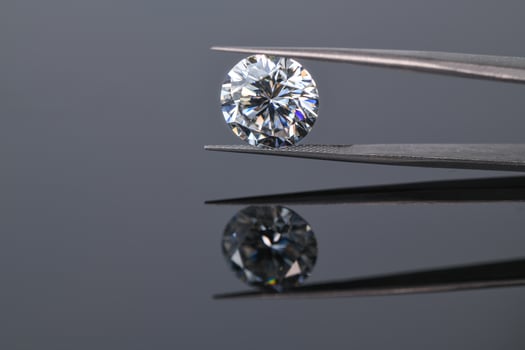Diamond in jeweler tweezers photo