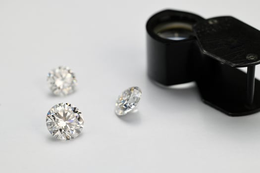 Diamonds and Jewelry Loupe on White Background photo