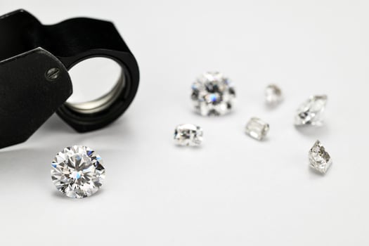 Diamonds and Jewelry Loupe on White Background photo