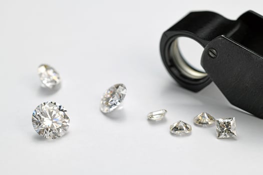 Diamonds and Jewelry Loupe on White Background photo