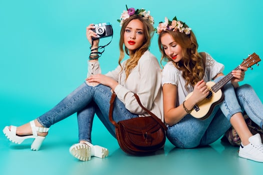 Studio lifestyle portrait of two pretty young blonde happy girls having fun. photo
