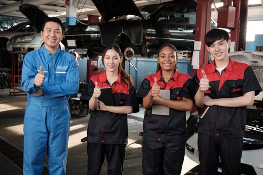 Portrait of multiracial professional mechanic team thumbs up and look at camera, work at car service garage, happy maintenance jobs, check and repair occupation in automotive industry business. photo