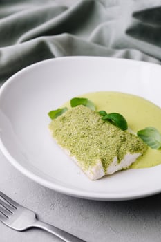 fried fish with basil sauce on plate photo