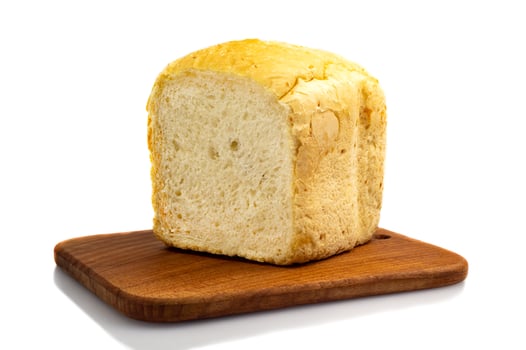Fresh white wheat homemade bread on a wooden board, isolate. Homemade cakes, pastries photo