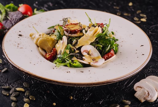 Warm salad with arugula, mushrooms and artichokes photo