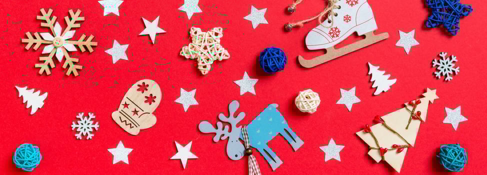 Banner top view of holiday toys and decorations on red Christmas background. New Year time concept photo