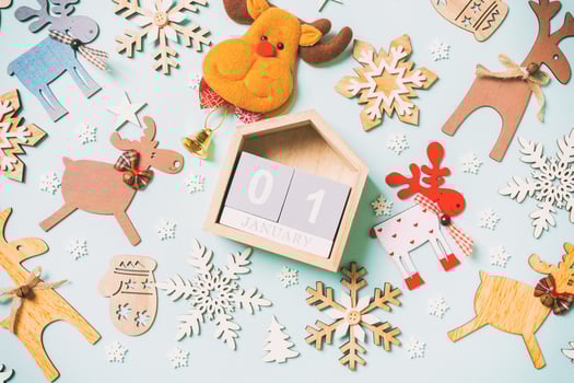 Top view of calendar on blue background made of holiday decorations and toys. Christmas ornament concept photo