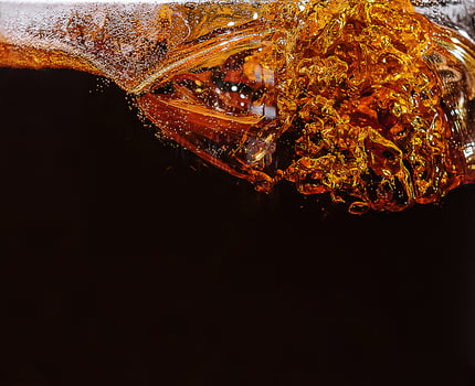 splashes in glass of dark Belgian beer photo