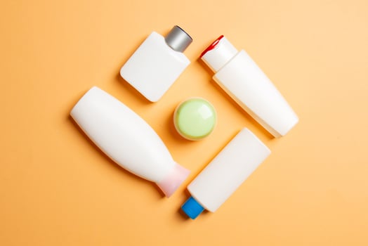 Set of White Cosmetic containers isolated on colored background, top view with copy space. Group of plastic bodycare bottle containers with empty space for you design photo