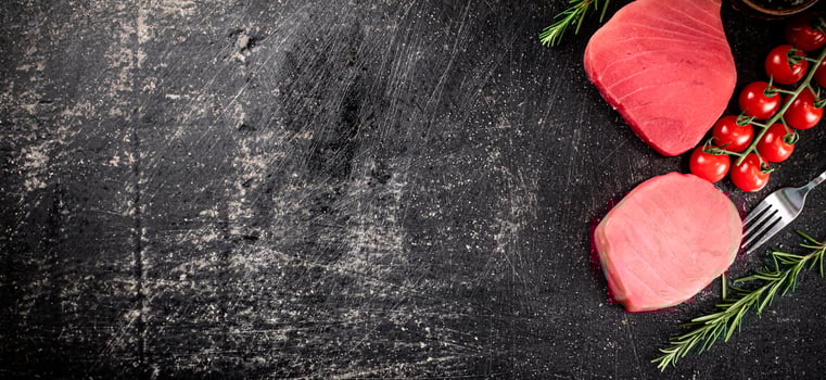 Fresh raw tuna steak with tomatoes and rosemary. photo