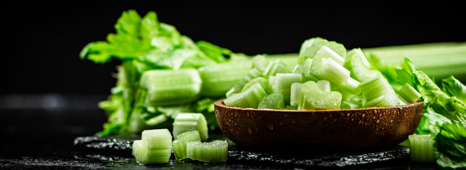 Pieces of fresh celery in a wooden plate. photo