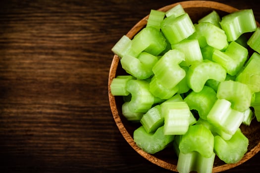 A wooden plate with a piece of celery. photo