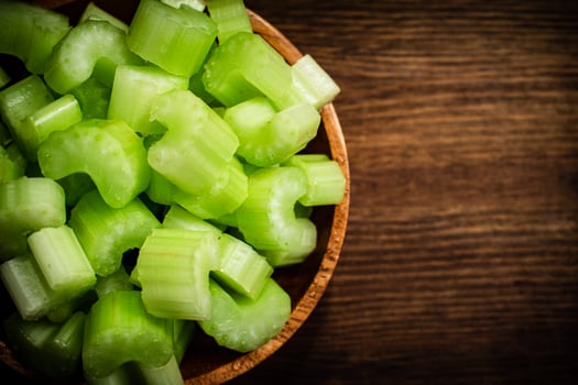 A wooden plate with a piece of celery. photo