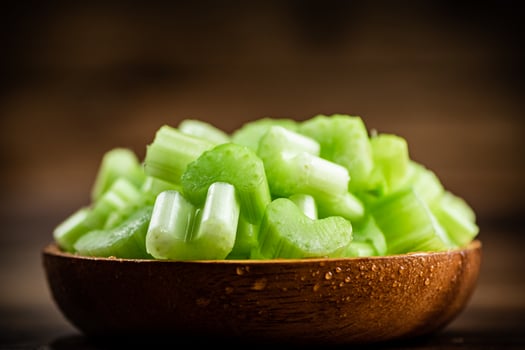 A wooden plate with a piece of celery. photo