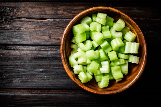Sliced fresh celery. On a dark wooden background. photo