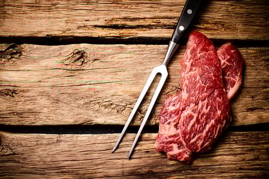 Fresh raw steak with fork. photo