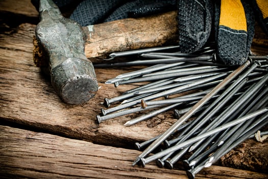 Hammer with nails and gloves on the table. photo