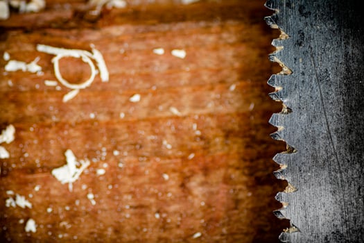 Hand saw blade on a wooden background. photo