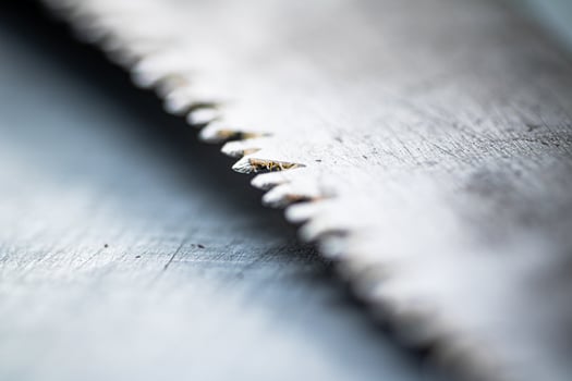 The blade of a hand saw on a gray background. photo